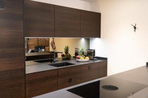 a kitchen with wooden cabinets and a sink at Terra Alpina in Arosa
