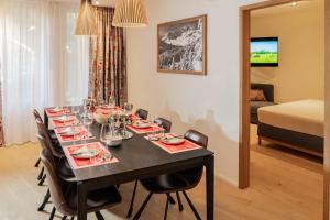 a dining room with a table with chairs and a room at Terra Alpina in Arosa