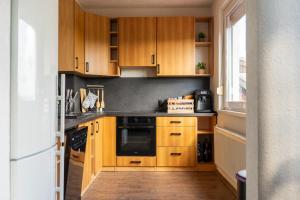 a small kitchen with wooden cabinets and a window at Waldberg Apartment in Nová Lesná