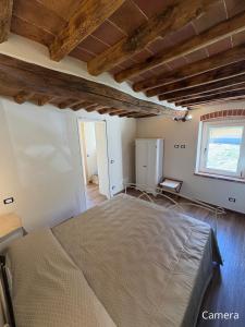 a bedroom with a bed and a window at Cà del Bosco Appartamento Castagno in Il Romito