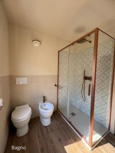 a bathroom with a toilet and a glass shower at Cà del Bosco Appartamento Castagno in Il Romito +6 photos