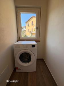 a washing machine in a room with a window at Cà del Bosco Appartamento Castagno in Il Romito