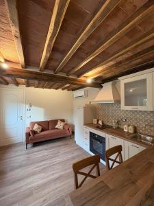 a kitchen and living room with a couch in a room at Cà del Bosco Appartamento Castagno in Il Romito