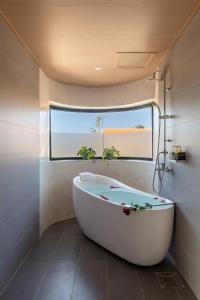 a bath tub in a bathroom with a window at Ban Mai Village in Phú Hiệp +110 photos