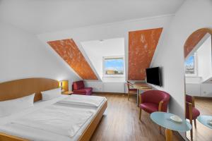 ein Schlafzimmer mit Bett, Schreibtisch und Stühlen in der Unterkunft Hotel SunParc - SHUTTLE zum Europa-Park Rust 4km & Rulantica 2km in Ringsheim