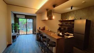 a kitchen with a counter and stools in a room at Biwako Villa 縁 in Takashima