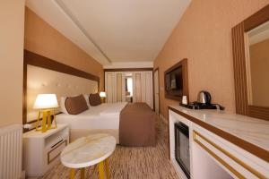 a hotel room with a bed and a television at Vera Vista Hotel in Ipekyolu