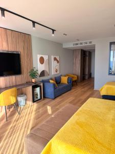 a living room with a blue couch and a tv at Esbjerg Hotel in Vlorë