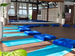 a yoga class with blue mats on the floor at Spaces Bali Unique Boutique Hotel in Canggu