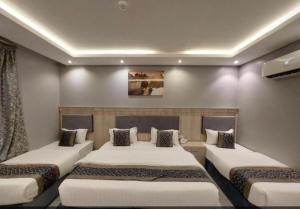 a room with three beds in a room at شقق ازار المخدومه in Medina