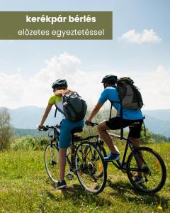 two people riding bikes on a grassy hill at Lumen Gasztropanzió in Eger