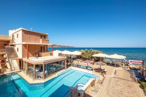 a hotel with a swimming pool next to the ocean at Kato Stalos Mare in Stalos