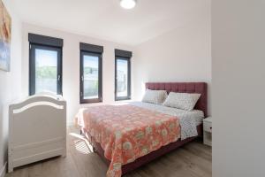 a white bedroom with a bed and windows at Villa Mirage in Blagaj