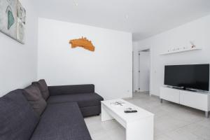 a living room with a couch and a tv at Villa Garasa in Cala Blanca