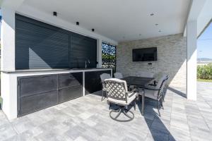 a patio with a table and chairs and a television at Villa Mirage in Blagaj