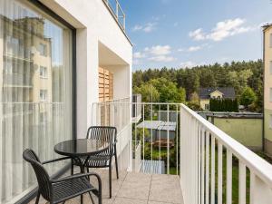 a balcony with two chairs and a table on a building at GRANO FLATS Sobieszewo - Villa Neptun in Sobieszewo