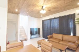 a living room with a couch and a ceiling fan at at60% - Vacation STAY 53162v in Nishibaru
