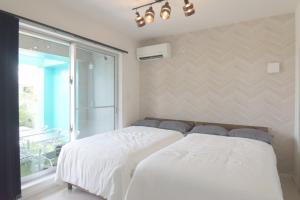 a white bed in a room with a window at at60% - Vacation STAY 53162v in Nishibaru +16 photos
