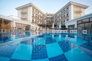 a hotel swimming pool in front of a building at Pasa Garden Beach in Marmaris