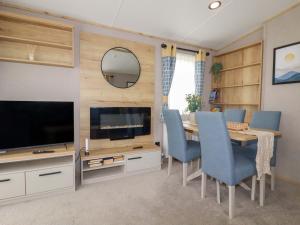a living room with a dining table and a television at Coastal Escape in Par