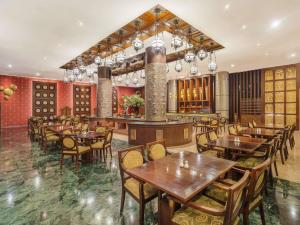 a restaurant with tables and chairs and a bar at The Royal Surakarta Heritage - Handwritten Collection in Solo