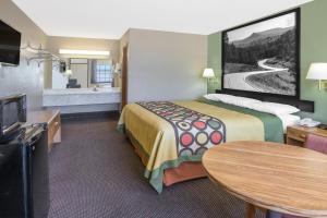 a hotel room with a bed and a bathroom at Super 8 by Wyndham Clarksville AR in Clarksville