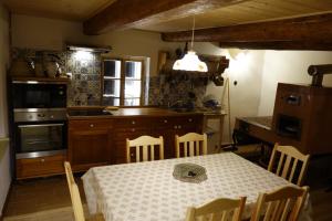 eine Küche mit einem Tisch, einem Tisch und Stühlen in der Unterkunft MausHaus in Rudník