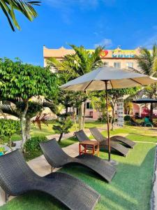 a group of chairs and a table and an umbrella at Cocomango's Resort in Taporok