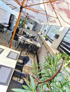 an outdoor patio with tables and chairs and an umbrella at Lumen Gasztropanzió in Eger