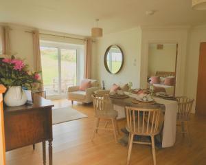 a living room with a table and chairs at Foxglove Cottage in Killean