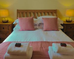 a bedroom with a bed with two towels on it at Foxglove Cottage in Killean
