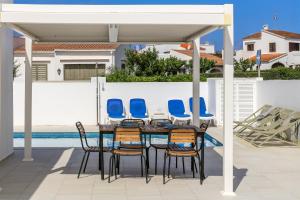 a patio with a table and chairs and a pool at Villa Izarenar in Cala Blanca