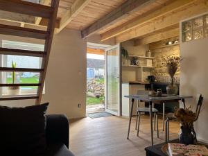a living room with a table and a kitchen at Le Clos d'Hydrequent in Rinxent