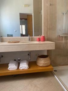 a bathroom with a sink and a mirror and towels at Residence Fazenda - Piscina in Praia +33 photos