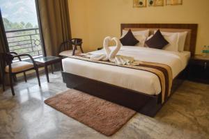 a bedroom with a bed with a swan decoration on it at Pinewood Manor in Dagshai