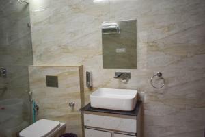 a bathroom with a sink and a mirror at Pinewood Manor in Dagshai +33 photos