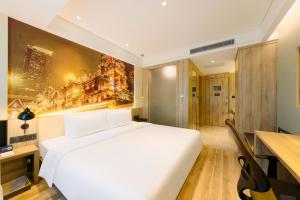 a bedroom with a large white bed and a desk at Atour Hotel Chongqing Jiefangbei in Chongqing