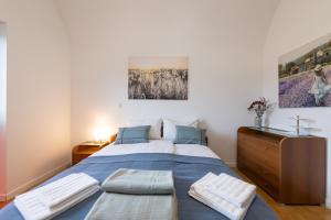 a bedroom with a blue bed with a wooden dresser at Apartma Drapšinova - Celje in Celje