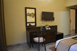 a hotel room with a desk and a mirror at Pinewood Manor in Dagshai