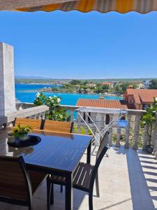 a blue table on a balcony with a view of the water at Apartmani Kaja, Vantačići, Otok Krk, A1 in Vantačići
