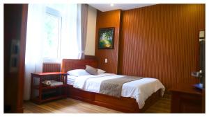 a bedroom with a bed and a window at Nam Xuan Premium Hotel in Da Lat +87 photos