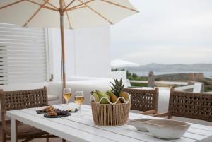 a table with a basket of fruit and wine glasses at Chrysalis Nature Villa 3 in Kampos Paros