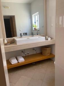 a bathroom with a white sink and a mirror at Residence Fazenda - Piscina in Praia