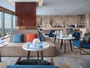 a restaurant with a couch and tables and chairs at Sofitel Guiyang Hunter in Guiyang