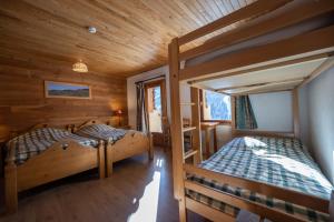 two bunk beds in a room with wooden walls at La Lobio in Molines-en-Queyras