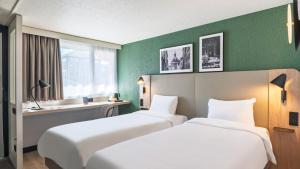 two beds in a room with green walls at Campanile NATURE - Lille Wasquehal in Wasquehal +23 photos