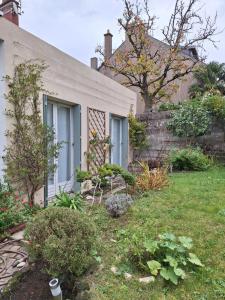 a white house with a garden in the yard at Maisonnette l'Olivier Bleu in Nantes +14 photos