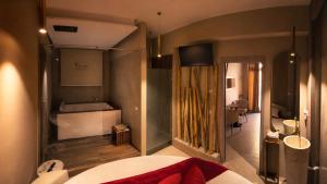 a bedroom with a bed and a bathroom with a tub at charme suite delux in Terrasini