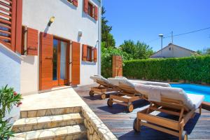 a patio with lounge chairs and a swimming pool at Villa San Vista with pool in Sveti Vid-Miholjice
