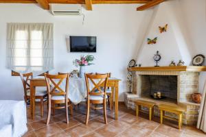 a dining room with a table and a fireplace at Kastanies Ananias Skopelos in Skopelos Town